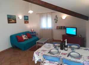 a living room with a table and a blue couch at House Mare e Monti by Holiday World in Albenga