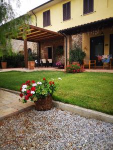 une maison avec un panier de fleurs dans la cour dans l'établissement Agriturismo Il Cuscino Nel Pagliaio, à Campiglia Marittima