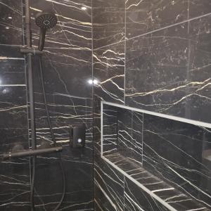 a bathroom with black marble walls and a shower at Riverside Toulouse (Savory) in Blagnac