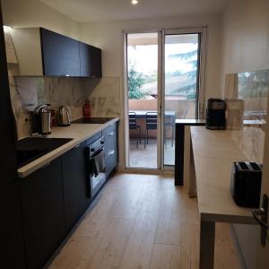 a kitchen with black cabinets and a wooden floor at Riverside Toulouse (Savory) in Blagnac