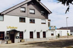 a white building with a brown roof at Hotel Anker garni in Rastatt