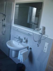 y baño con lavabo y espejo. en Hotel Anker garni en Rastatt