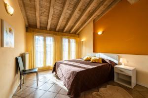 a bedroom with a bed and a chair in a room at Flowers Apartments in Desenzano del Garda