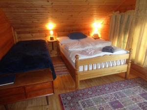 1 dormitorio con 2 camas en una cabaña de madera en Guesthouse Elínar Helgu en Fáskrúðsfjörður