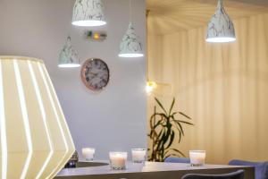 a table with candles and a clock on a wall at Palladium Hotel in Kriopigi