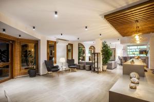 a living room with chairs and a couch and a table at Palladium Hotel in Kriopigi