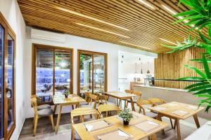 a restaurant with wooden tables and chairs at Palladium Hotel in Kriopigi