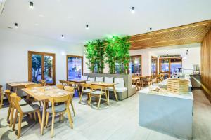 a restaurant with tables and chairs and a kitchen at Palladium Hotel in Kriopigi