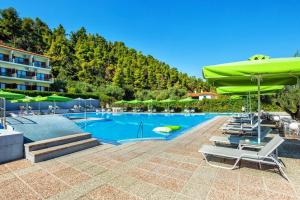 a pool at a hotel with chairs and umbrellas at Palladium Hotel in Kriopigi