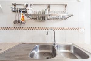a stainless steel sink in a kitchen with utensils at Casa Meravigliosa in Ostuni +12 photos