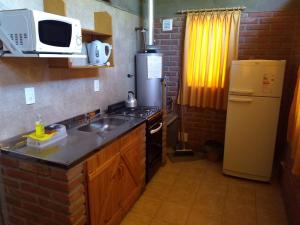 a kitchen with a sink and a microwave and a refrigerator at Cabañas del Bosque Bariloche in San Carlos de Bariloche +77 photos