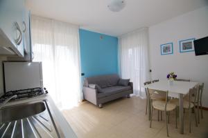 eine Küche und ein Wohnzimmer mit einem Sofa und einem Tisch in der Unterkunft Appartamento Olimpo in San Benedetto del Tronto