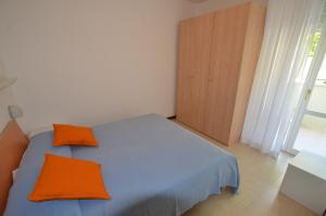 ein Schlafzimmer mit einem blauen Bett und zwei orangefarbenen Kissen in der Unterkunft Appartamento Olimpo in San Benedetto del Tronto
