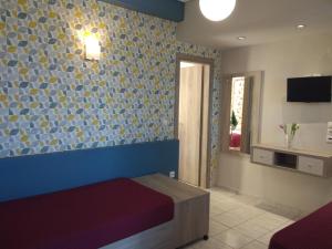 a room with a bed and a wall with blue and yellow tiles at Apartment Toula in Petra