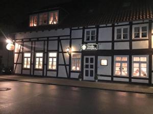 ein schwarzweißes Gebäude in der Nacht auf einer Straße in der Unterkunft Wolfs Gasthaus in Braunschweig