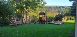 a park with a playground and a bench and a swing at Agroturystyka Stokrotka in Rymanów-Zdrój