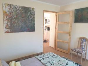 uma sala de estar com um quadro na parede e uma cadeira em St. Rita Guesthouse em Lókút