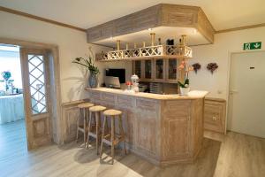a kitchen with a bar with stools in a room at Hotel Papenbreer in Verl