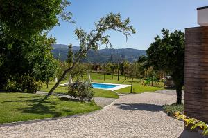 una piscina en un jardín con una casa en Regada House en Vieira do Minho