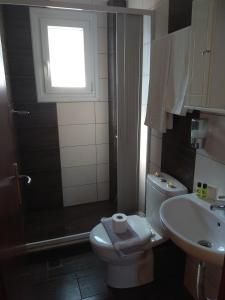 a bathroom with a toilet and a sink and a window at Apartment Toula in Petra +85 photos