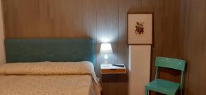 a bedroom with a bed and a table and a lamp at Pensión CASA LEÓN in Santoña