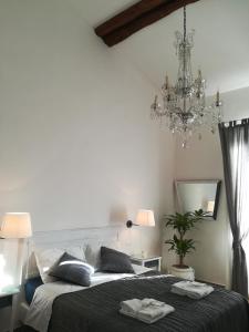 um quarto com uma cama grande e um lustre em In San Frediano B&B em Florença