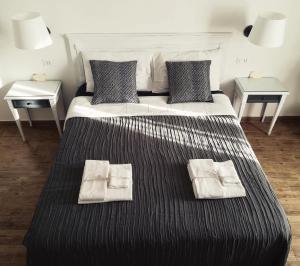 ein Schlafzimmer mit einem großen Bett mit zwei Tischen in der Unterkunft In San Frediano B&B in Florenz