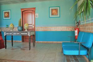 a room with a table and a blue wall at Hotel Medusa in Lampedusa