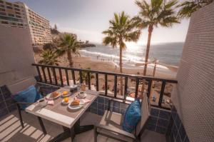a table and chairs on a balcony with a view of the beach at Beach Apartment 3 in Patalavaca