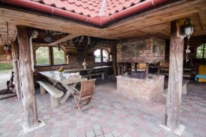 un patio al aire libre con mesa y chimenea en Dandzenieki, en Pāvilosta