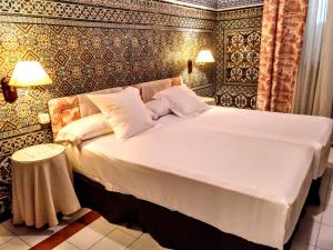 セビリアにあるホテル シモンのベッドルーム1室(白い大型ベッド1台付)