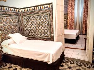 a bedroom with a bed and a bathroom with a tub at Hotel Simon in Seville