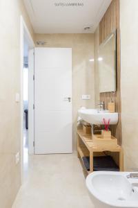 y baño con lavabo blanco y espejo. en Suites Lumbreras, en Sevilla