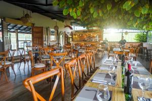uma sala de jantar com mesas e cadeiras de madeira em Finca Hotel Yerbabuena em Pereira