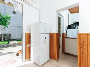 a kitchen with a white refrigerator and wooden cabinets at Kesi beach house in Volos