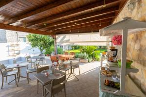 un patio avec tables, chaises et un parasol dans l'établissement B&B L'isola che non c'è, à Torre San Giovanni