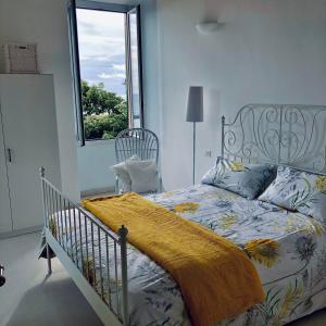 una camera da letto con un letto con una coperta e una finestra di Casa del cardinale a Santo Stefano al Mare