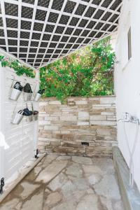 a patio with a stone wall and a window at Kesi beach house in Volos