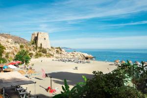 a beach with a castle and the ocean at Casa Chana in Almuñécar