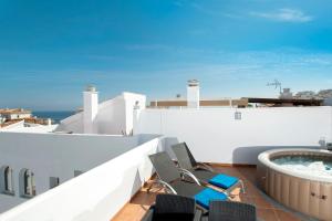 a balcony with chairs and a hot tub on a building at Casa Chana in Almuñécar