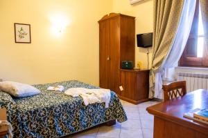 ein Schlafzimmer mit einem Bett, einem Schrank und einem Tisch in der Unterkunft Hotel Il Cavalier D'Arpino in Arpino