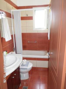 een badkamer met een wastafel, een toilet en een raam bij Stella Apartments in Petra
