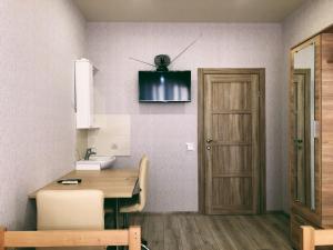 eine Küche mit einem Tisch und einem TV an der Wand in der Unterkunft Annet in Kharkov