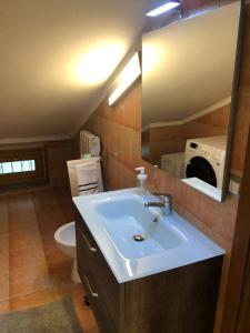 a bathroom with a sink and a toilet and a mirror at Il Gatto sulla Luna, ai piedi delle Langhe in Narzole