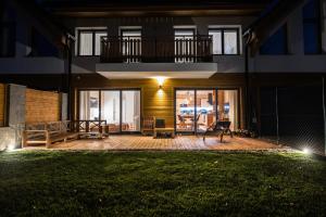 a house with a patio at night at Lomnica Garden Apartment in Tatranská Lomnica +17 photos
