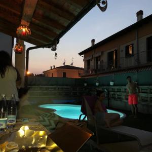 a group of people sitting around a swimming pool at villa anna in Sarego