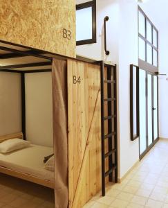 Zimmer mit einem Etagenbett und einer Holztür in der Unterkunft Hostel Numero Trece in Alicante