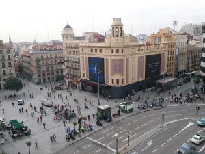 a busy city street with a large building with people at Hostal Continental in Madrid