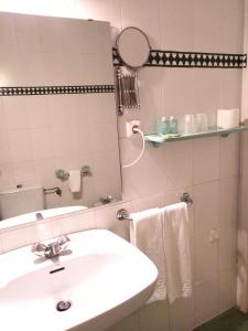a bathroom with a sink and a mirror at Hotel Simon in Seville