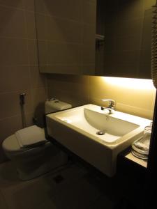 a bathroom with a white sink and a toilet at D Hotel in Seri Iskandar
